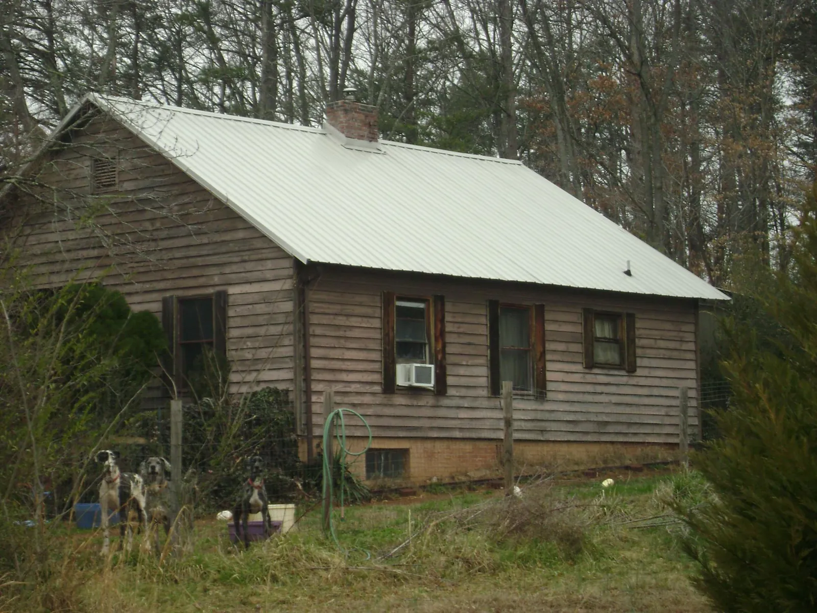 White metal roof on an old wood sided farmhouse, from a Metal Roof Installation job in Saint Benedict